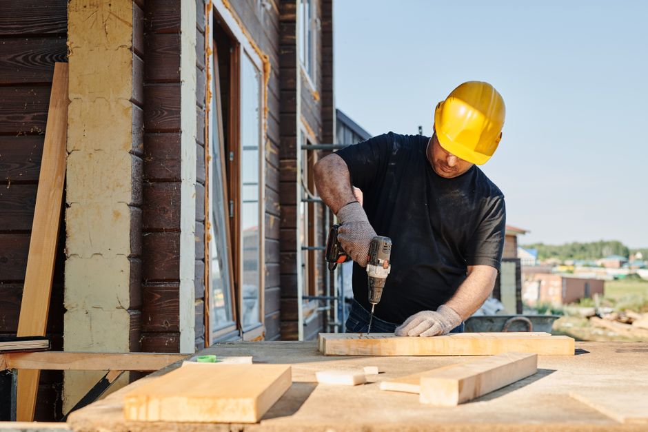 Professional home improvement contractor measuring for window installation